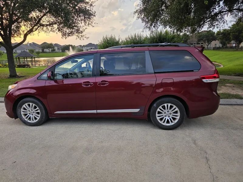 Red 2013 Toyota Sienna XLE side profile with sliding doors near Houston TX